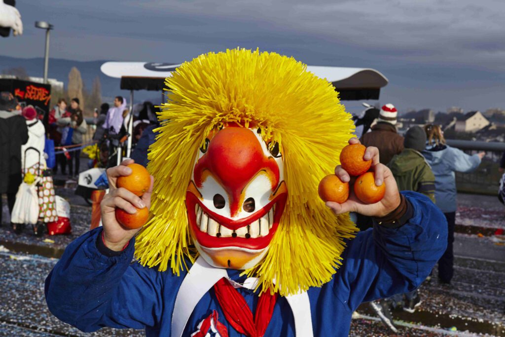Carnival of Basel Participant (Waggis - a classic figure of the Carnival of Basel, Switzerland) Holding Oranges, Symbolizing Culinary Delights